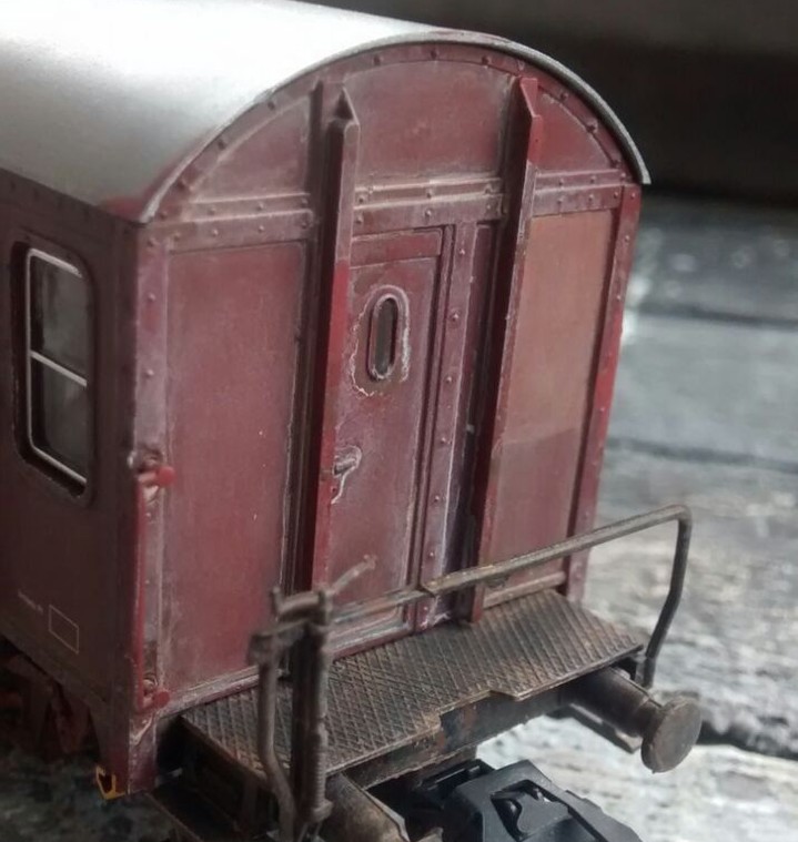 Die Lasur aus "Beige" ueigt sich auch an dem kleinen Fenster in der Tür der Stirnseite des Pwghs-54 Güterzug-Begleitwagen.