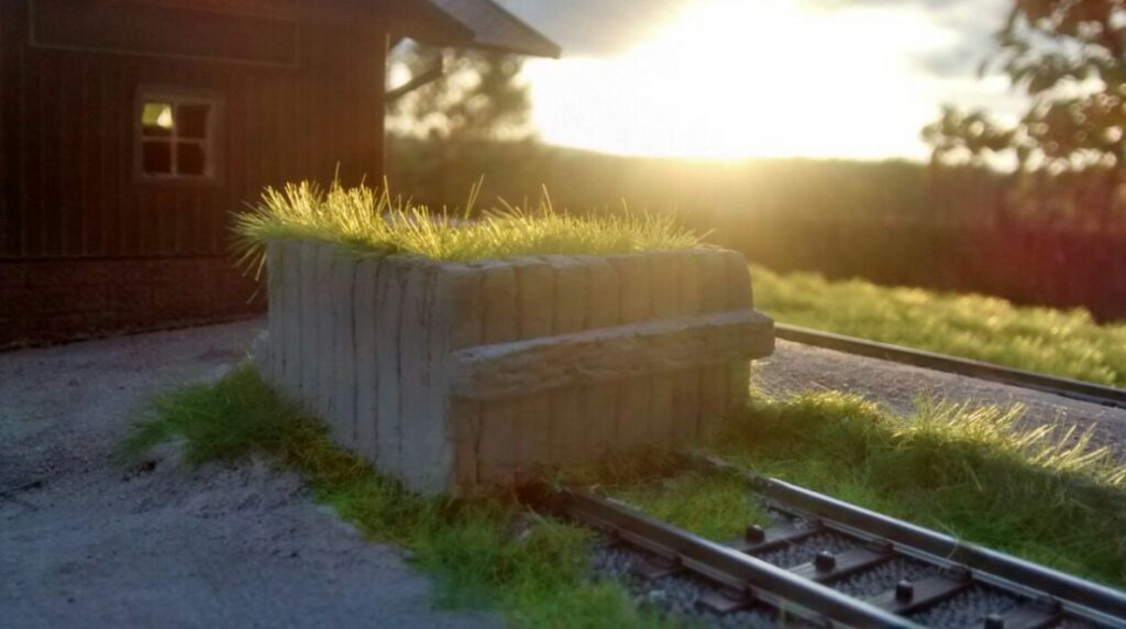 Der Prellbock am Bahnhof Heimbuchenthal. Die Grashalme recken sich ins Abendlicht. Niemand gebietet ihrem fröhlichen Wachstum Einhalt. Recht so!