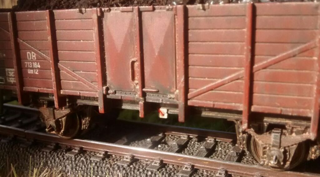 Der Blick schräg von der Seite macht die Ergebnisse von Doncolors Arbeit sichtbar: Der Hell/Dunkel-Kontrast der Güterwagen-Wand und das Verschmutzen des Bereichs unter den seitlichen Ladetüren standen im Fokus bei Doncolor. Ansonsten ist er recht naturbelassen, der Offene Güterwagen der Verbandsbauart Om 12 der DB mit der Betriebsnummer: 713 164.