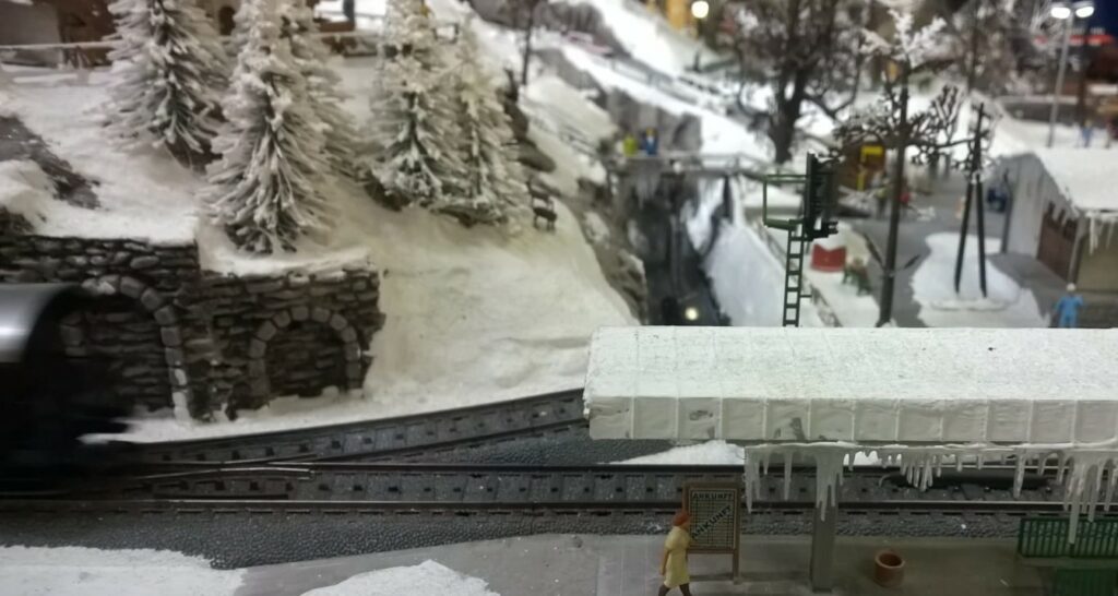 Kleine Szene an der Bahnhofseinfahrt. Dicke Eiszapfen hängen an der schneebedeckten Überdachung des Bahnsteigs.