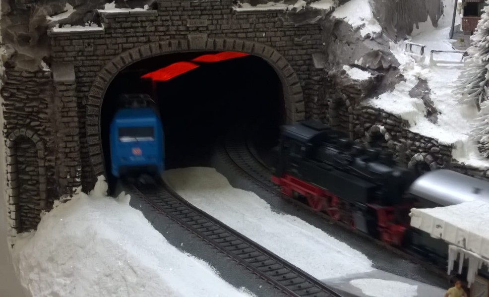 Die drei Märklin 44818 Offener Güterwagen Jim Knopf Lavawagen schicken sich an, an der Märklin 39374 Elektrolokomotive BR 101 071-9 den Tunnel zu verlassen.