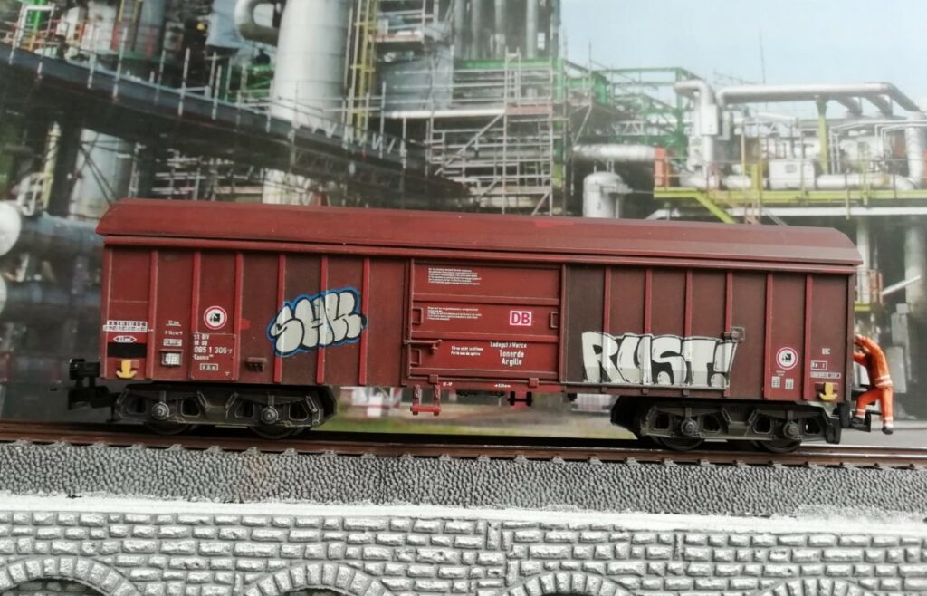 Graffiti auf dem Märklin 44600 Taems 890, "Tonerde / Argille", Betriebsnummer 31 80 085 1 306-7. Doncolors Alterung / Patinierung von Modellbahnfahrzeugen wie hier einem Güterwagen.