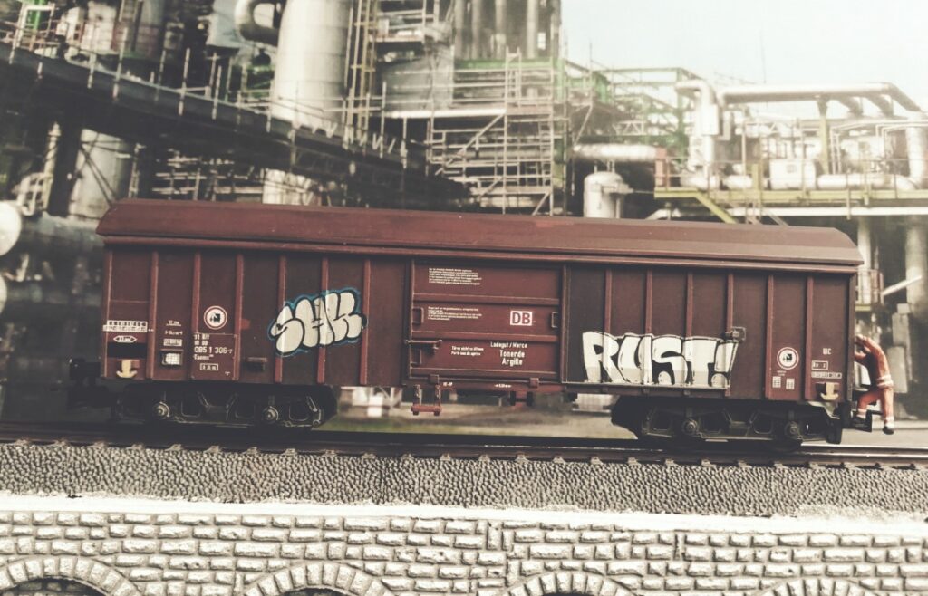Graffiti auf dem Märklin 44600 Taems 890, "Tonerde / Argille", Betriebsnummer 31 80 085 1 306-7. Doncolors Alterung / Patinierung von Modellbahnfahrzeugen wie hier einem Güterwagen.