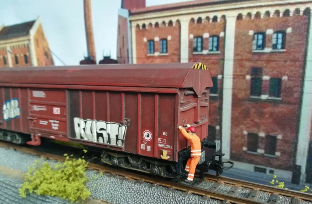 Nach dem Aufbringen der Graffiti: Der Rangierer an dem Märklin 44600 Taems 890, "Tonerde / Argille", Betriebsnummer 31 80 085 1 306-7. Doncolors Alterung / Patinierung von Modellbahnfahrzeugen wie hier einem Güterwagen.