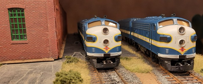 Die beiden F7 aus dem Set Märklin 3481 US-Diesellok EMD F7 "Texas & Pacific" vor der Werkhalle auf zwei Abstellgleisen.