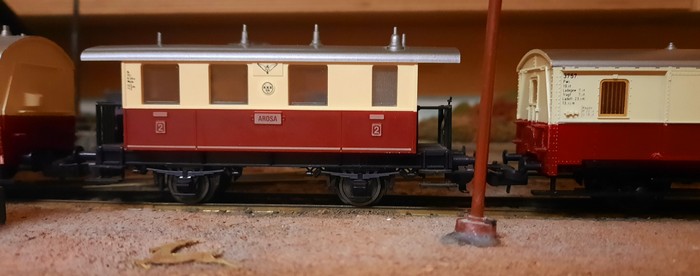 Hier hängt der Fleischmann 5056 zweiachsigen Personenwagen 2. Klasse "AROSA" an dem Trix 3755 Abteilwagen rot/beige 2./3. Klasse und dem Trix 3757 Privatbahnwagen Gepäckwagen Pw