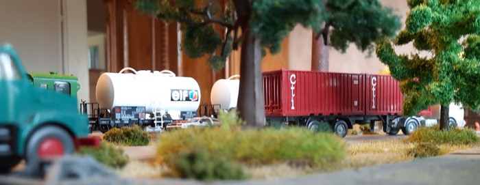 Neben dem Wiking H0 524 Mb 2223 Cti Stahl Container Sattelzug Saure 839/1 A stehen die Fleischmann 5415 "OMV" V Z Kesselwagen