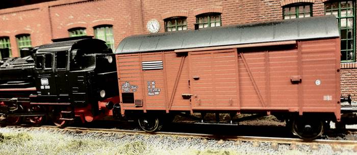 Dieser Roco 47527 Gedeckter Güterwagen Bauart Hkms 2224 Wagennummer 27 NC 50 DR 222 4117-6 steht seitlich der Halle auf dem halb vergessenen Gleisstrang.