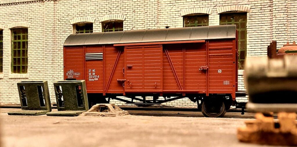 In der Werkhalle: ein Roco 47527 Gedeckter Güterwagen Bauart Hkms 2224 Wagennummer 27 NC 50 DR 222 4117-6 bereit zum Entladen.