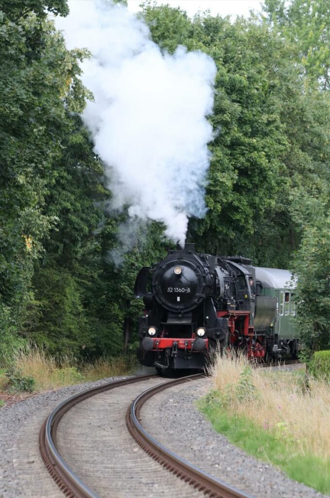 Die Dampflok Baureihe 52 1360-8 mit Wannentender schnauft vor einem Personenzug mit Personenwagen vom Typ B4üm-63 im Wald bei Aschaffenburg. (Foto: Josef)