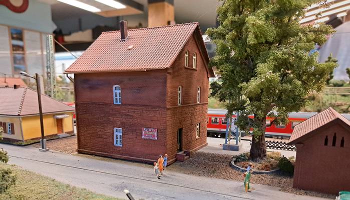 Bei diesem Nebengebäude handelt es sich wohl um ein Wohnhaus für Bahnbedienstete. Neben dem uralten mächtigen baum wirkt das Gebäude aus rotem Backstein sehr beschaulich.